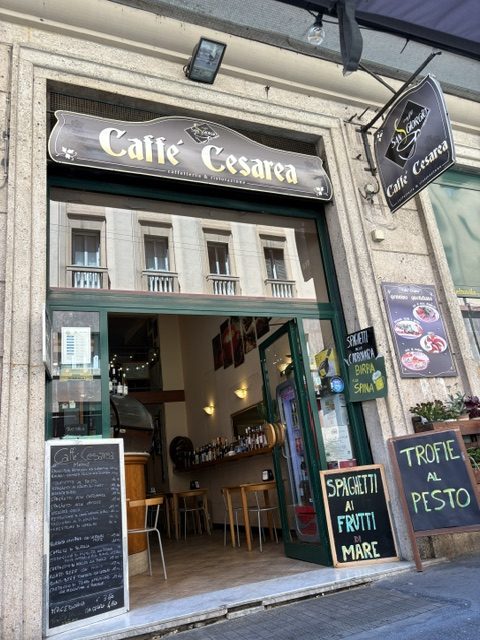 Storefront of Caffè Cesarea with chalkboard menus advertising seafood spaghetti and pesto