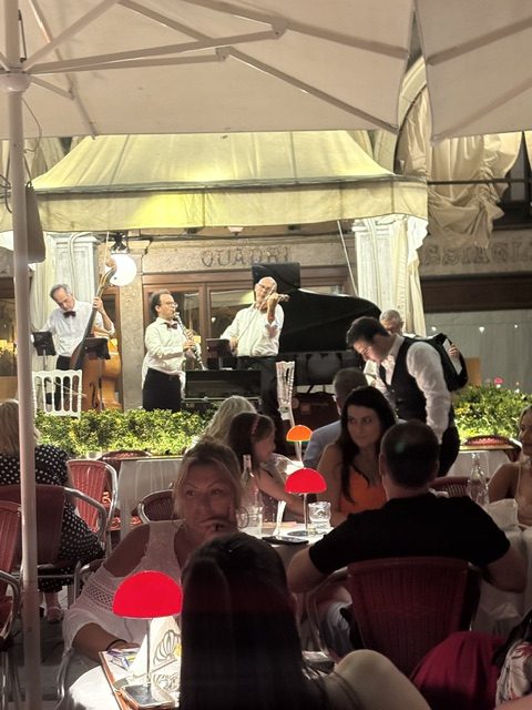 Dining under an awning with musicians