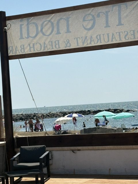 Restaurant sign with beach behind